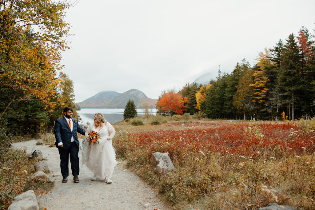 Bride and groom walking in Autumn landscape at their elopement.