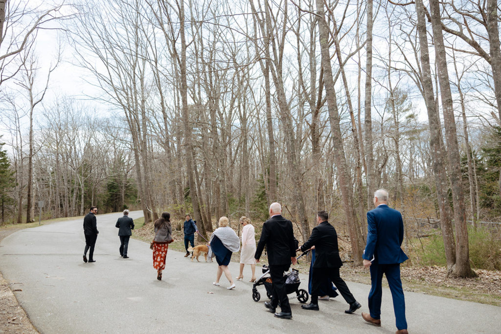 Wedding guests walking to ceremony at elopement in Maine