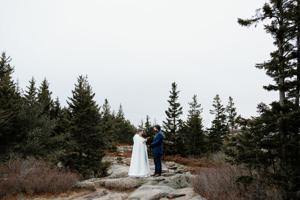 Bride and groom intimate wedding ceremony on cliffs in Acadia