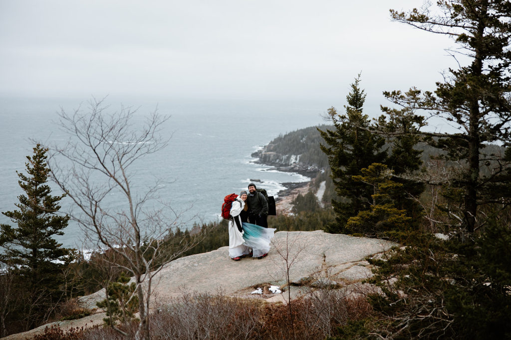 Bride and groom hiking at elopement in Maine