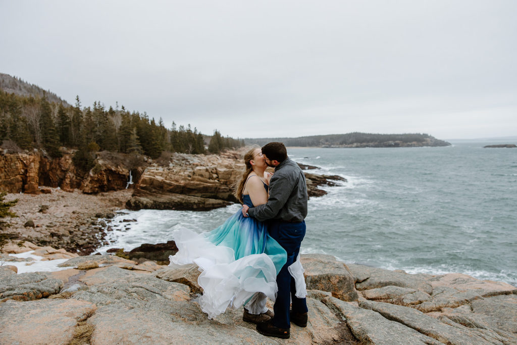 Bride in blue wedding dress kissing groom in Acadia elopement photo