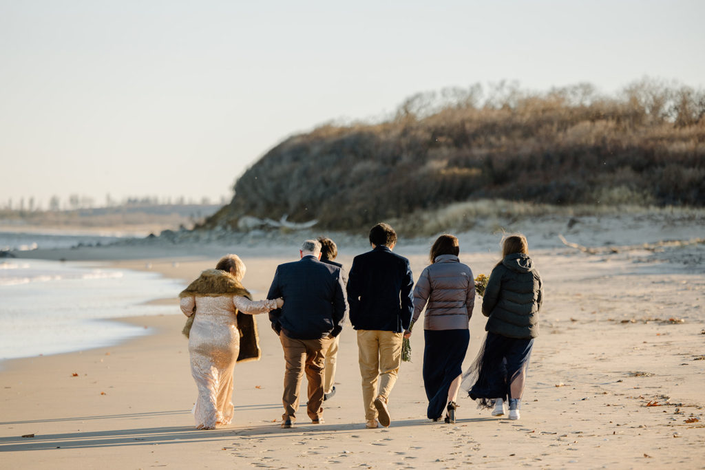 Family all walking together on the beach at parents elopement
