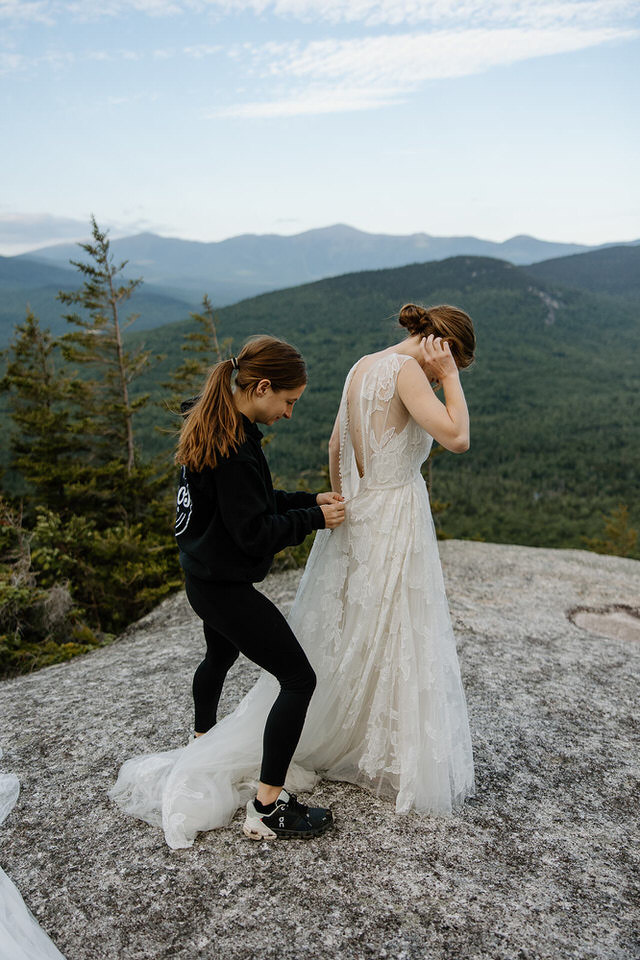 bride getting dressed on mountain for elopement ceremony