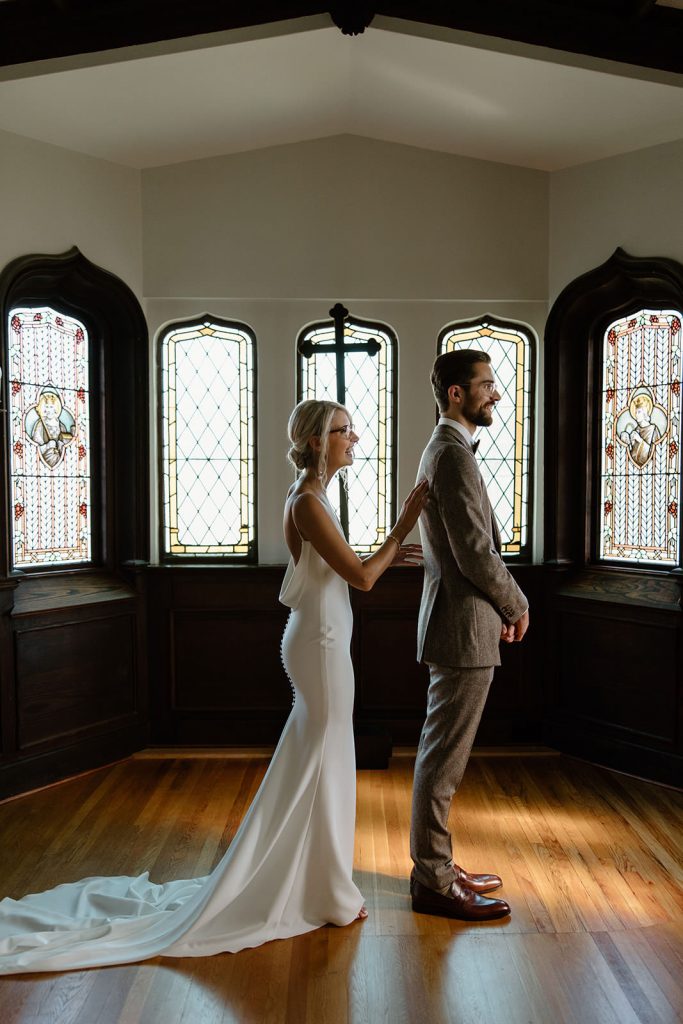 Bride and groom first look in Airbnb with stained glass windows.